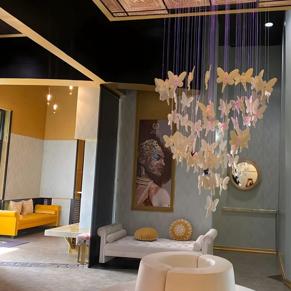 Aroma Restaurant & Lounge interior with butterfly chandelier, African art, and modern seating.