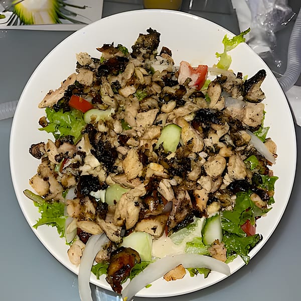 Aroma Restaurant & Lounge's African chicken salad with lettuce, tomatoes, cucumbers, and onions.