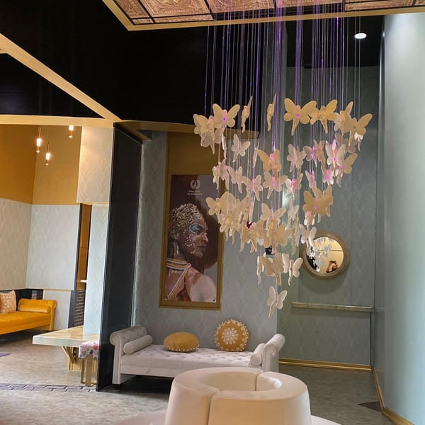 Aroma Restaurant & Lounge interior with a butterfly chandelier, African art, and elegant seating.